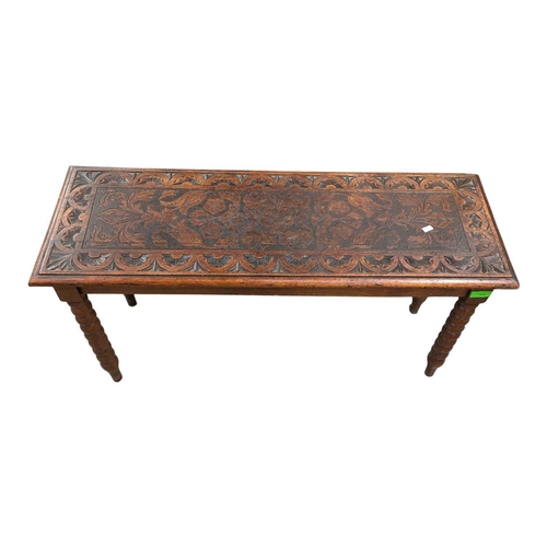 916 - A 19th century carved oak coffee table. Having a carved border with central field featuring foliate ... 