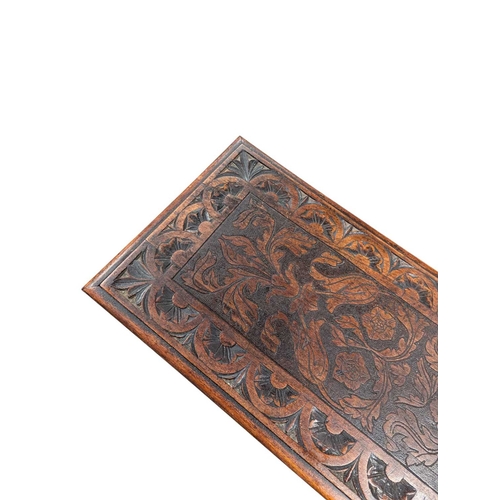 916 - A 19th century carved oak coffee table. Having a carved border with central field featuring foliate ... 