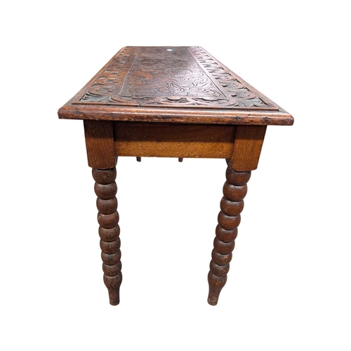 916 - A 19th century carved oak coffee table. Having a carved border with central field featuring foliate ... 