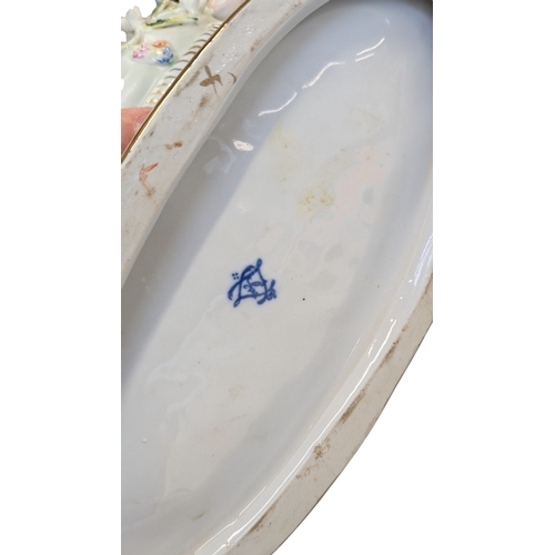 100 - A 20th century German Dresden style porcelain centre piece having figural putti to each side with fl... 