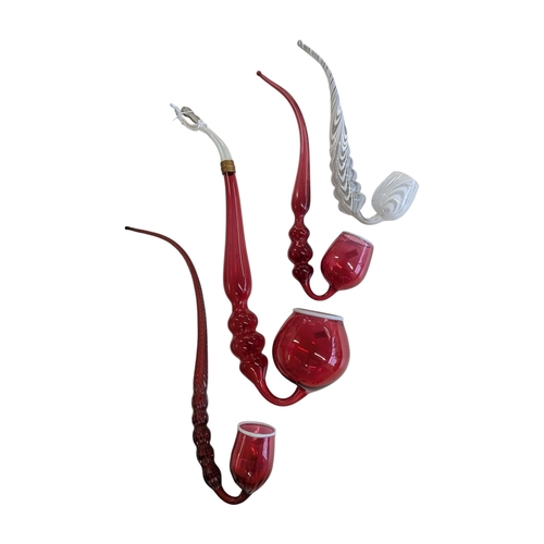 114 - A collection of four 19th century Victorian glass Nailsea pipes. Cranberry glass with white rims on ... 