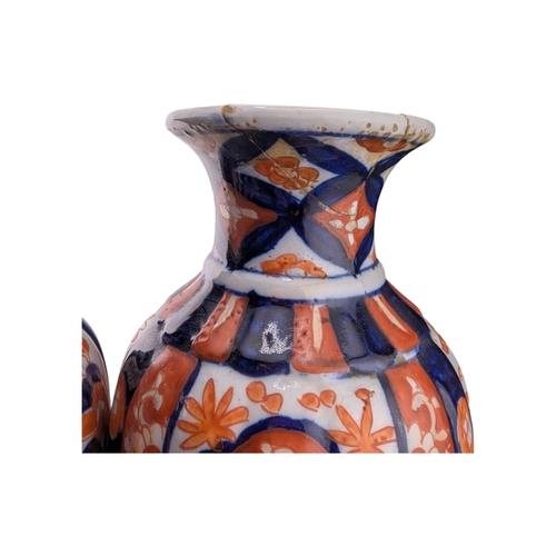 94 - Pair of late 19th century Japanese imari vases. Of scalloped baluster form and decorated with a red ... 