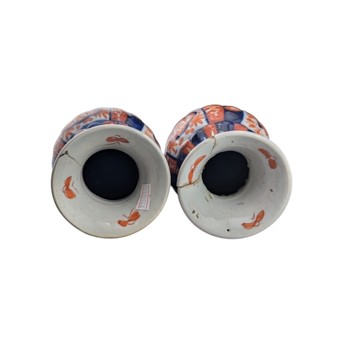 94 - Pair of late 19th century Japanese imari vases. Of scalloped baluster form and decorated with a red ... 