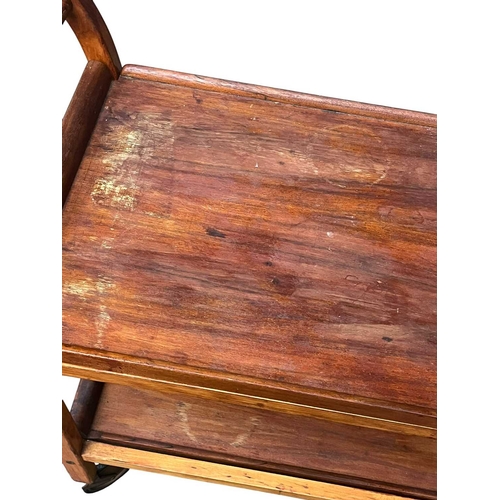 627 - British Modern Design - A mid century teak wood butlers trolley. Raised on squared legs with twin ti... 