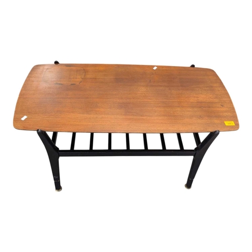 648 - A mid-century British design tola wood coffee table with ebonised legs and slatted magazine rack bel... 