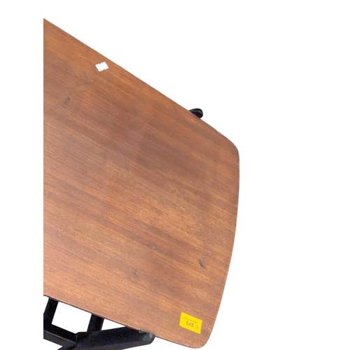 648 - A mid-century British design tola wood coffee table with ebonised legs and slatted magazine rack bel... 