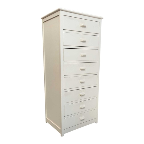 650 - A 20th century white painted semainier pedestal chest of drawers. The chest having a bank of eight d... 