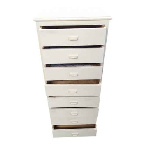 650 - A 20th century white painted semainier pedestal chest of drawers. The chest having a bank of eight d... 