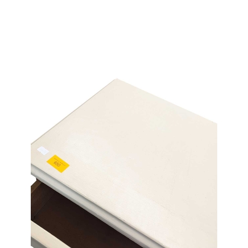 650 - A 20th century white painted semainier pedestal chest of drawers. The chest having a bank of eight d... 