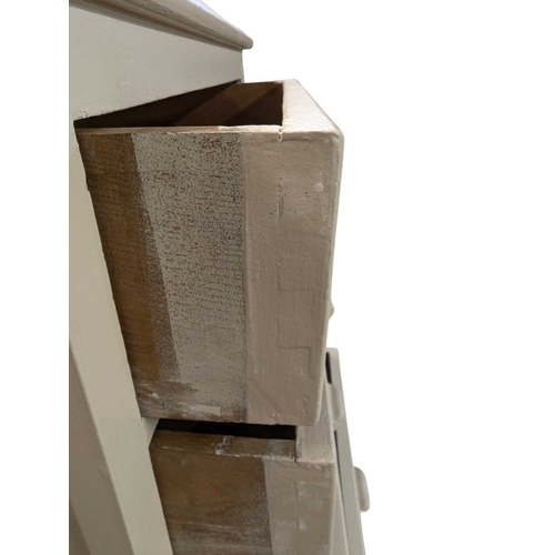 650 - A 20th century white painted semainier pedestal chest of drawers. The chest having a bank of eight d... 