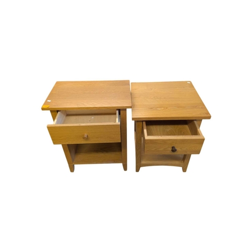 652 - A pair of contemporary oak bedside tables / side tables. Each having overhanging top with drawer ben... 