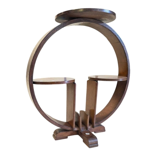 656 - An Art Deco oak display stand / magazine rack. Having a circular top with curved supports, with smal... 