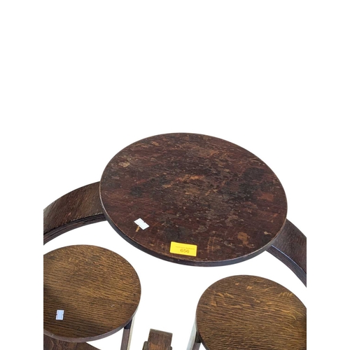 656 - An Art Deco oak display stand / magazine rack. Having a circular top with curved supports, with smal... 