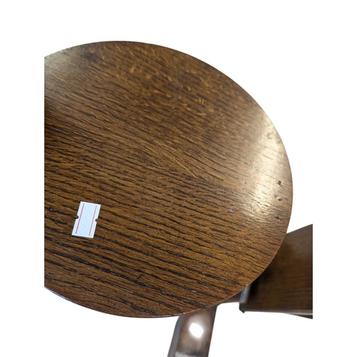 656 - An Art Deco oak display stand / magazine rack. Having a circular top with curved supports, with smal... 