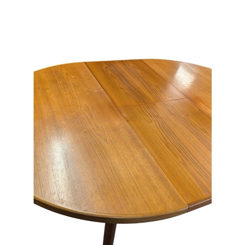 664 - Mid century teak extending dining table along with a set of 4 curved spindle back chairs having tart... 