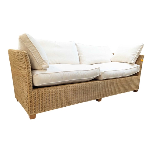 666 - A large contemporary rattan whicker weave conservatory sofa with large squab white cushions. Measure... 
