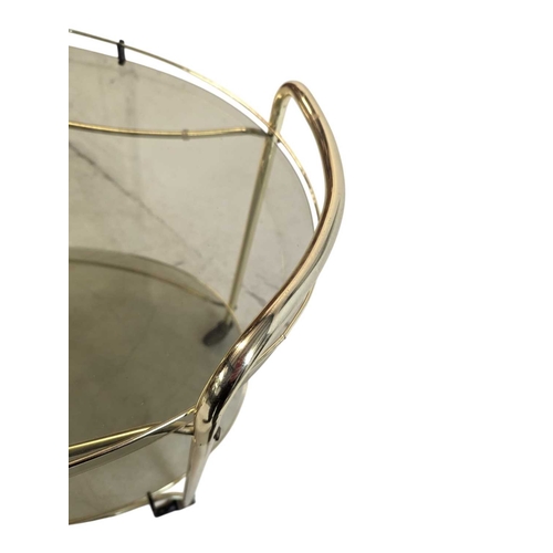 674 - A contemporary brass and smoked glass drinks / hostess trolley in the Art Deco style. Having gilt tu... 