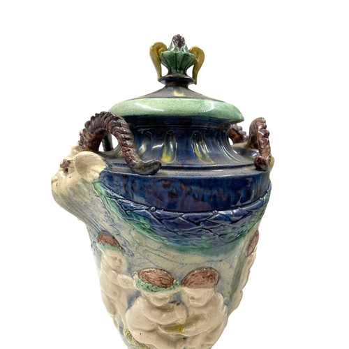 159 - A pair of late 19th century hand painted Majolica grotesque lidded urns. Each vase having a shaped l... 