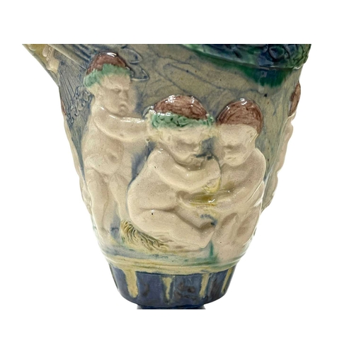 159 - A pair of late 19th century hand painted Majolica grotesque lidded urns. Each vase having a shaped l... 