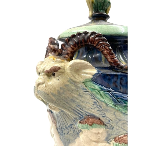 159 - A pair of late 19th century hand painted Majolica grotesque lidded urns. Each vase having a shaped l... 