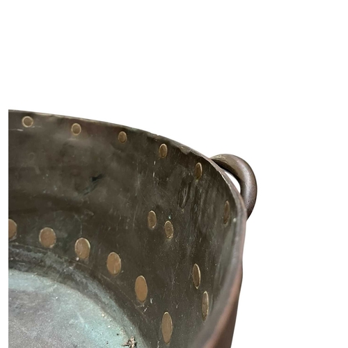 540 - A 19th century copper & studded bucket/cauldron. The large bucket of circular tapering form with... 