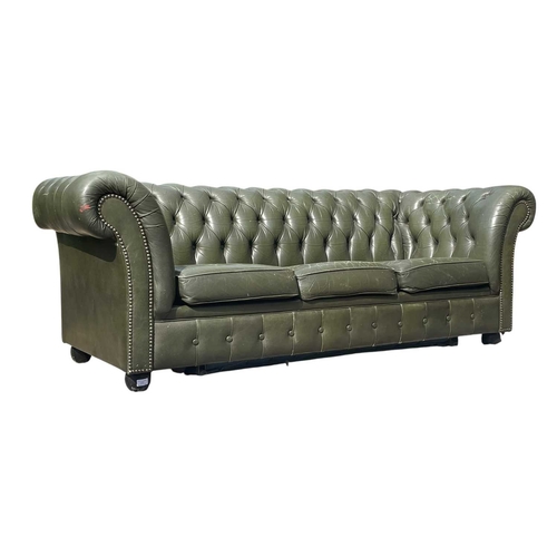 623 - A Chesterfield style 20th century green leather buttoned back three seater sofa. With scrolled elbow... 