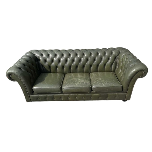 623 - A Chesterfield style 20th century green leather buttoned back three seater sofa. With scrolled elbow... 