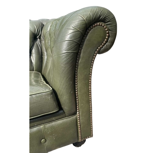 623 - A Chesterfield style 20th century green leather buttoned back three seater sofa. With scrolled elbow... 